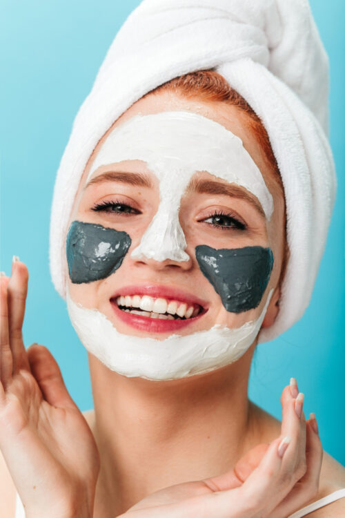 blithesome-young-woman-doing-spa-treatment-studio-shot-laughing-girl-with-towel-face-mask
